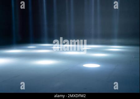 rayons de lumière flous sur le sol de la discothèque. projecteurs au néon bleu blanc. lignes laser et effet d'éclairage. scène vide de nuit en studio avec refle néon Banque D'Images