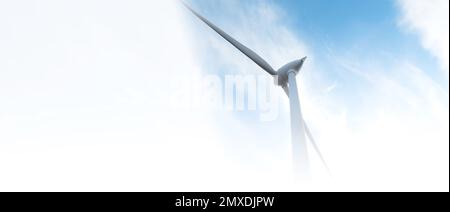 parc éolien ou ferme de moulin à vent de bannière floue, avec des éoliennes à fort vent pour la production d'électricité. Concept de production d'énergie verte. Les développeurs durables Banque D'Images