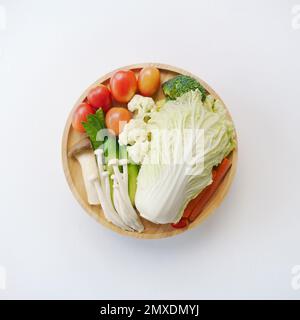 vue de dessus plat lay mélanger légumes frais avec chou chinois, champignons, tomate, carotte, pois verts, concombre, brocoli sur bois plaque ronde fond blanc.id Banque D'Images