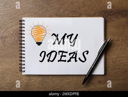 Carnet avec des mots MON IDÉE et stylo sur table en bois, vue de dessus Banque D'Images