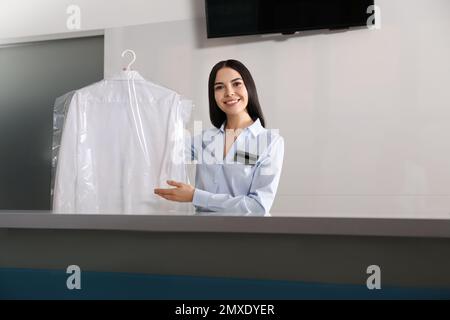 Femme travaillant avec une chemise sur un sèche-linge moderne Banque D'Images