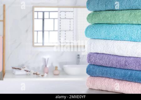 Pile de serviettes propres sur une table gris clair dans la salle de bains. Espace pour le texte Banque D'Images