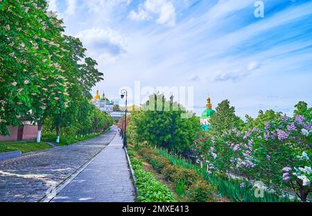 Le parc verdoyant avec des châtaignes et des lilas fleuris avec vue sur la forteresse de Kiev Pechersk Lavra Cave Monastère derrière la végétation luxuriante, K Banque D'Images