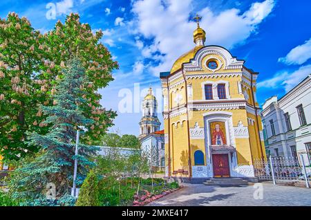 La façade de l'église rotonda de Sergius de Radonezh avec châtaignier fleuri à côté et la grande tour de cloche de Kiev Pechersk Lavra Cave Monaster Banque D'Images