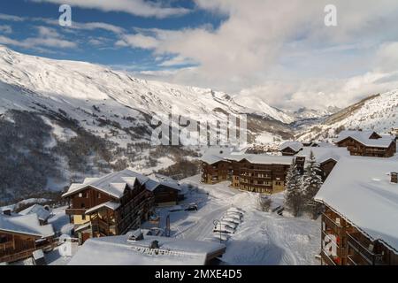 Le toit du chalet se trouve aux Menuires après une nouvelle chute de neige au début de 2023. Ciel bleu au-dessus et montagne s en arrière-plan. Banque D'Images