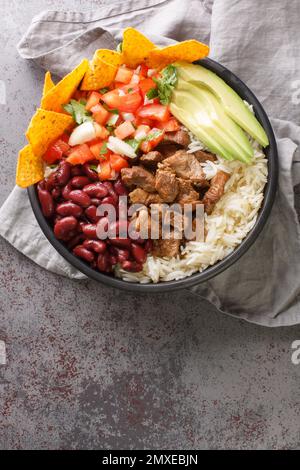 Bol Chifrijo à base de viande frite, de riz et de haricots sur l'assiette de la table. Vue verticale du dessus Banque D'Images