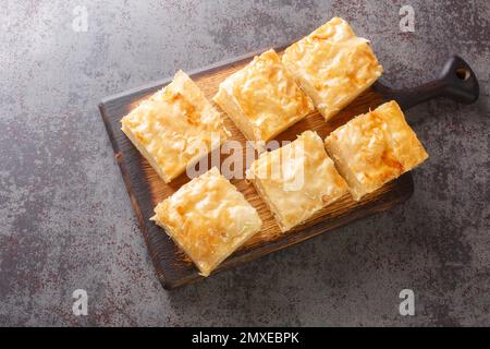 Pâtisserie sucrée maison galaktoboureko avec crème semoule sur le panneau de bois sur la table. Vue horizontale du dessus Banque D'Images