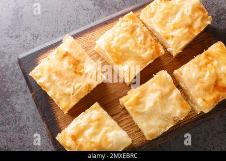 Tarte grecque à la crème anglaise Galaktoboureko avec crème semoule sur le panneau en bois de la table. Vue horizontale du dessus Banque D'Images