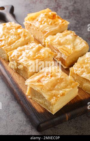 Galaktoboureko est un dessert grec, turc, laz et syrien de crème anglaise semoule cuite en filo sur le panneau en bois de la table. Verticale Banque D'Images