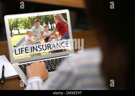 Femme avec un ordinateur portable moderne à l'intérieur, en gros plan. Assurance vie Banque D'Images