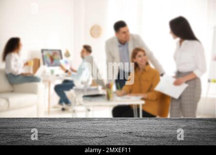 Surface en pierre vide et vue floue des designers d'intérieur professionnels travaillant au bureau, en gros plan. Espace pour le texte Banque D'Images