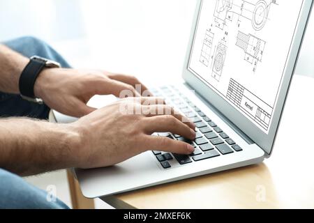 Ingénieur travaillant avec le dessin technique sur ordinateur portable à la table, gros plan Banque D'Images