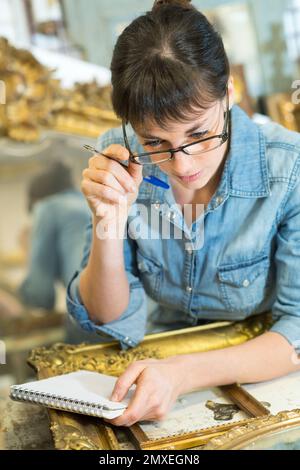 femme dans la galerie regardant le bloc-notes Banque D'Images