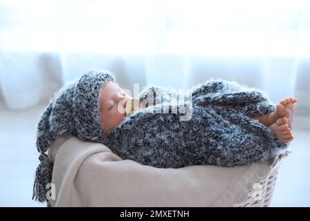 Mignon bébé nouveau-né de dormir dans le panier à la maison Banque D'Images