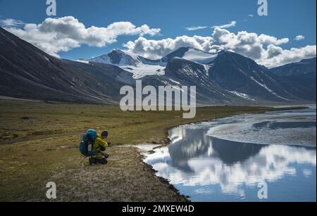 Col Akshayuk, île de Baffin, Canada. Vue arrière des randonneurs, vue spectaculaire sur la montagne depuis le sommet Banque D'Images