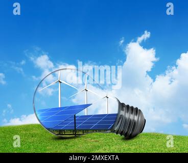 Source d'énergie alternative. Ampoule avec panneaux solaires et éoliennes à l'extérieur Banque D'Images