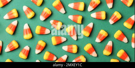 Composition de la couche plate avec de délicieux cornes de bonbons sur fond vert. Bannière Banque D'Images