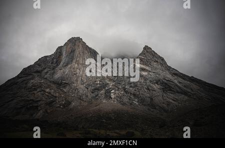Face sud-ouest de Mt. Thor, la plus haute falaise verticale de la Terre, un jour nuageux de septembre. Randonnée dans la vallée sauvage et reculée de l'arctique du col Akshayuk, Baffin Banque D'Images