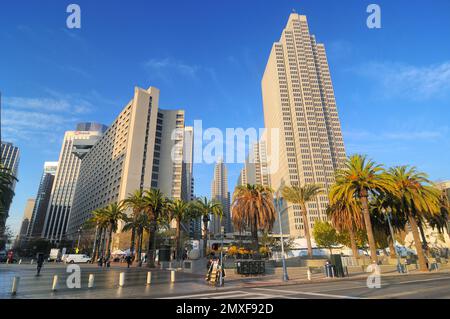 Un paysage urbain dynamique avec de hauts bâtiments modernes et des palmiers sous un ciel bleu clair. La zone urbaine animée présente Embarcadero Center. Banque D'Images