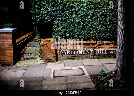 Parlement Hill NW3 panneau de rue sur le mur cassé sous la haie verte la nuit Banque D'Images