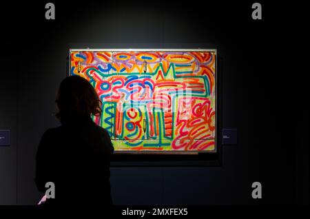 Trieste, Italie - 21 janvier 2023: Femme regardant l'œuvre Keith Haring, sans titre, 1983. Peinture pulvérisée sur le bois. Exposition intitulée The Great Communicat Banque D'Images