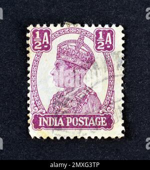 Timbre-poste annulé imprimé par l'Inde, qui montre le portrait du roi George VI portant la couronne impériale de l'Inde, vers 1941. Banque D'Images