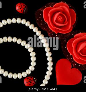 une rose rouge et un collier de perles blanches sur fond noir, formes de coeur, concept de jour de valentin. Banque D'Images