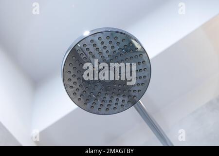 Pomme de douche fixée au mur du bac de douche. Douche avec le spray du dessus sur la buse Banque D'Images