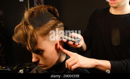 coiffage et coupe de cheveux pour hommes avec la machine à raser barber, coupe de cheveux pour homme. Salon de coiffure avec rasoir dans un salon de coiffure moderne avec une clé noire Banque D'Images