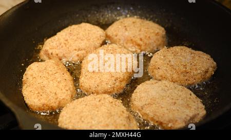 Côtelettes frites dans une poêle à frire avec de l'huile de tournesol. Menu rustique. Cuisine rustique traditionnelle. Gros plan. Côtelettes de hamburgers faites maison Banque D'Images