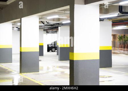 Une seule voiture garée à l'extrémité d'un grand parking neuf et vide, très lumineux et propre à Sao Paulo au Brésil Banque D'Images