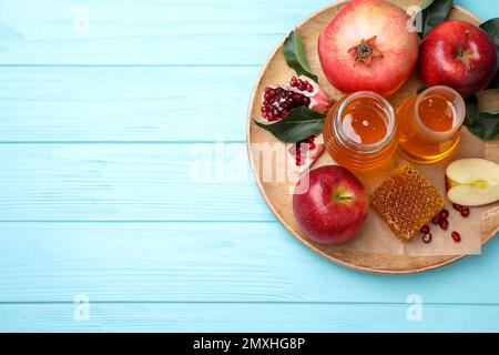 Vue de dessus du miel, des pommes et des grenades sur une table en bois bleu clair, espace pour le texte. Vacances de Rosh Hashanah Banque D'Images