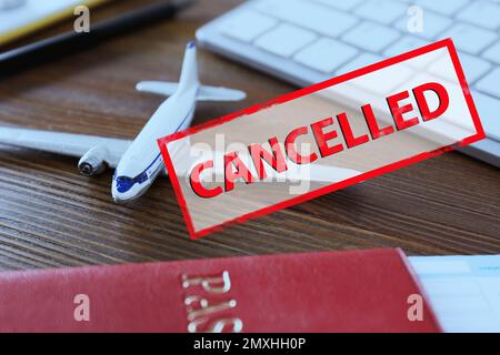 Fermeture du trafic aérien par quarantaine pendant l'éclosion du coronavirus. Jouet avion, passeport et timbre avec inscription ANNULÉE Banque D'Images