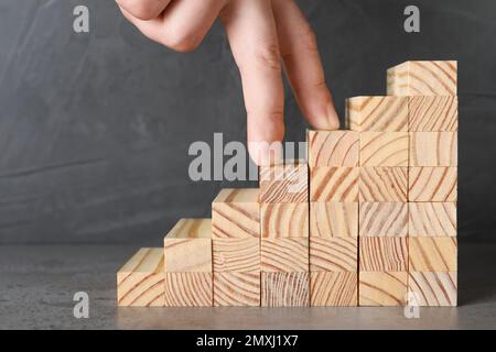 Homme imitant monter sur des escaliers en bois avec ses doigts, gros plan. Échelle de carrière Banque D'Images