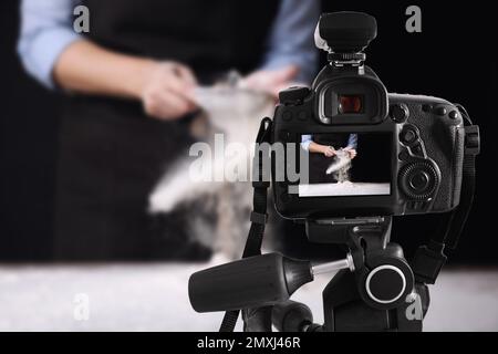 Photographie alimentaire. Prise de vue d'une femme qui tamise la farine, mise au point sur l'appareil photo Banque D'Images