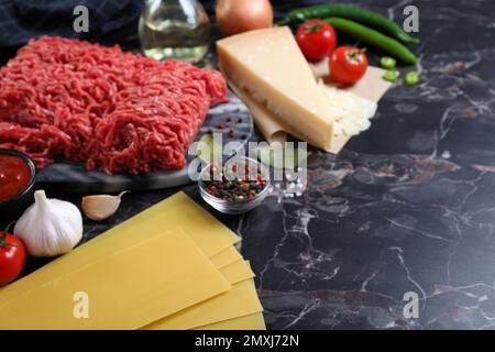 Ingrédients frais pour lasagnes sur table en marbre noir Banque D'Images