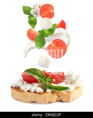 Bruschetta savoureuse avec des ingrédients volants sur fond blanc Banque D'Images