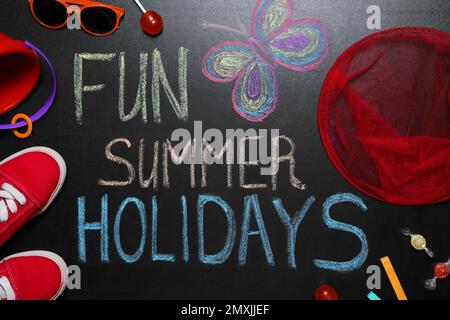 Composition Flat Lay avec chaussures pour enfant et inscription Fun Summer Holidays sur tableau noir. Pause-école Banque D'Images