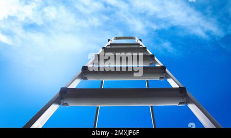 Escabeau en métal contre ciel bleu avec nuages, vue en angle bas. Bannière Banque D'Images