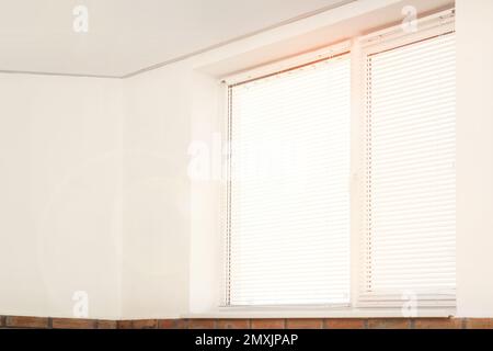 Fenêtre avec stores dans la chambre par beau temps Banque D'Images