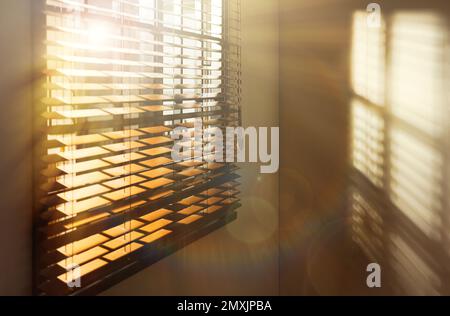 Le soleil brille à travers les stores dans la chambre Banque D'Images