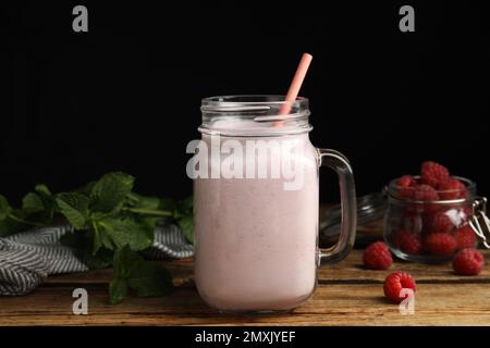 Savoureux milk shake avec des framboises et de la menthe sur une table en bois Banque D'Images