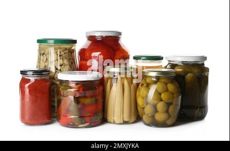 Pots en verre avec différents légumes marinés et champignons sur fond blanc Banque D'Images