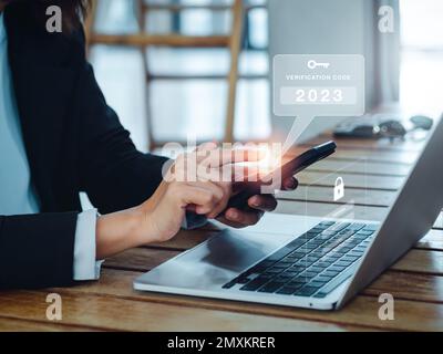 Concept d'authentification en deux étapes (2FA). 2023, alerte de code de vérification et d'icône de clé sur le smartphone lors de l'utilisation de l'ordinateur pour la page Web de validation du mot de passe, Banque D'Images