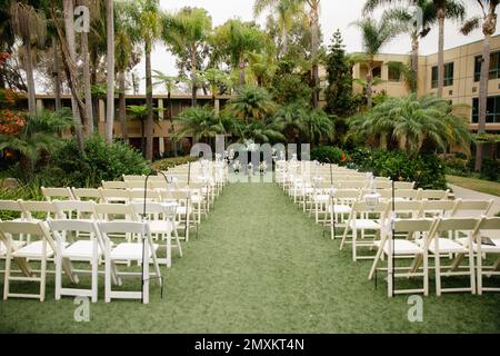 Lieu de mariage tropical nuageux - cérémonie organisée avec des arbres en bois blanc, des palmiers et des lanternes vintage Banque D'Images