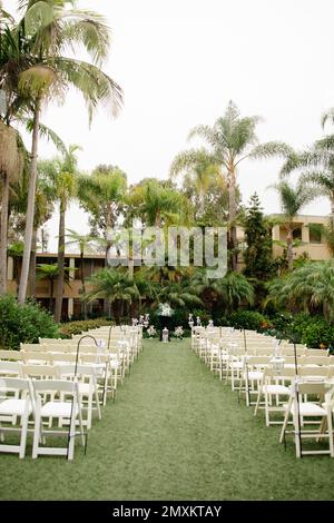 Lieu de mariage tropical nuageux - cérémonie organisée avec des arbres en bois blanc, des palmiers et des lanternes vintage Banque D'Images