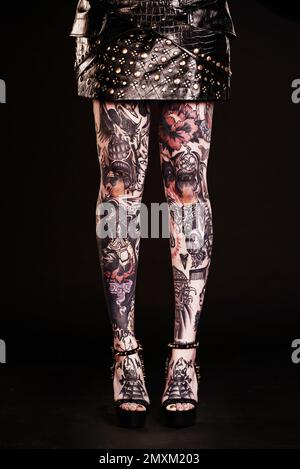 Style tatouage de la tête aux pieds. Photo de studio d'une femme tatouée jambes. Banque D'Images