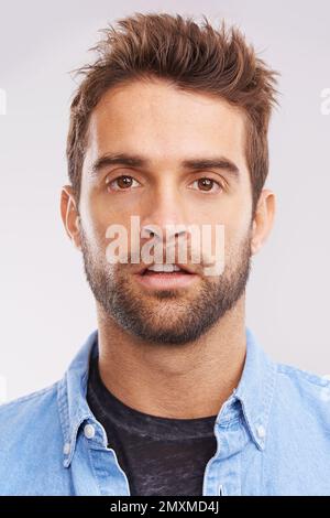 Lapin MR. Studio portrait d'un jeune homme faisant un visage de lapin sur fond gris. Banque D'Images