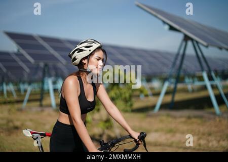 Active style de vie jeune homme coureur courir par panneaux solaires ferme à l'extérieur arrière-plan d'été. Concept de durabilité Banque D'Images