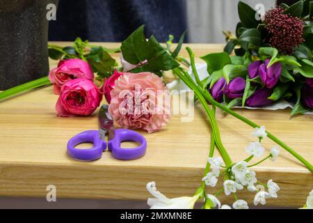 des ciseaux pour couper des fleurs se trouvent sur une table avec des fleurs dans un fleuriste Banque D'Images